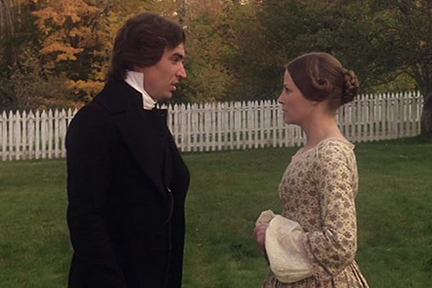 A man and woman wearing period costumes looking at each other.