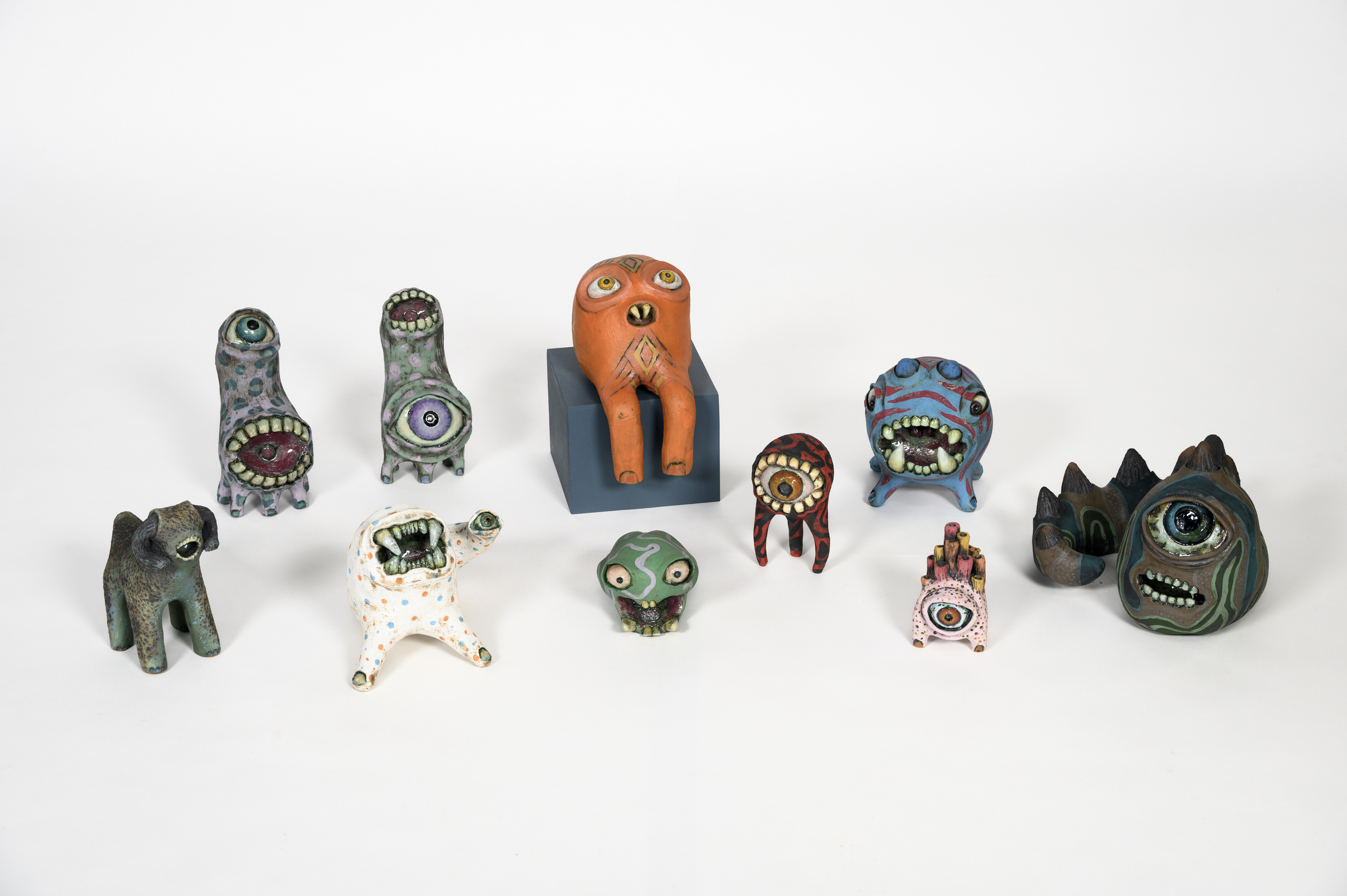 Ten colourful clay sculptures of monster-like characters.