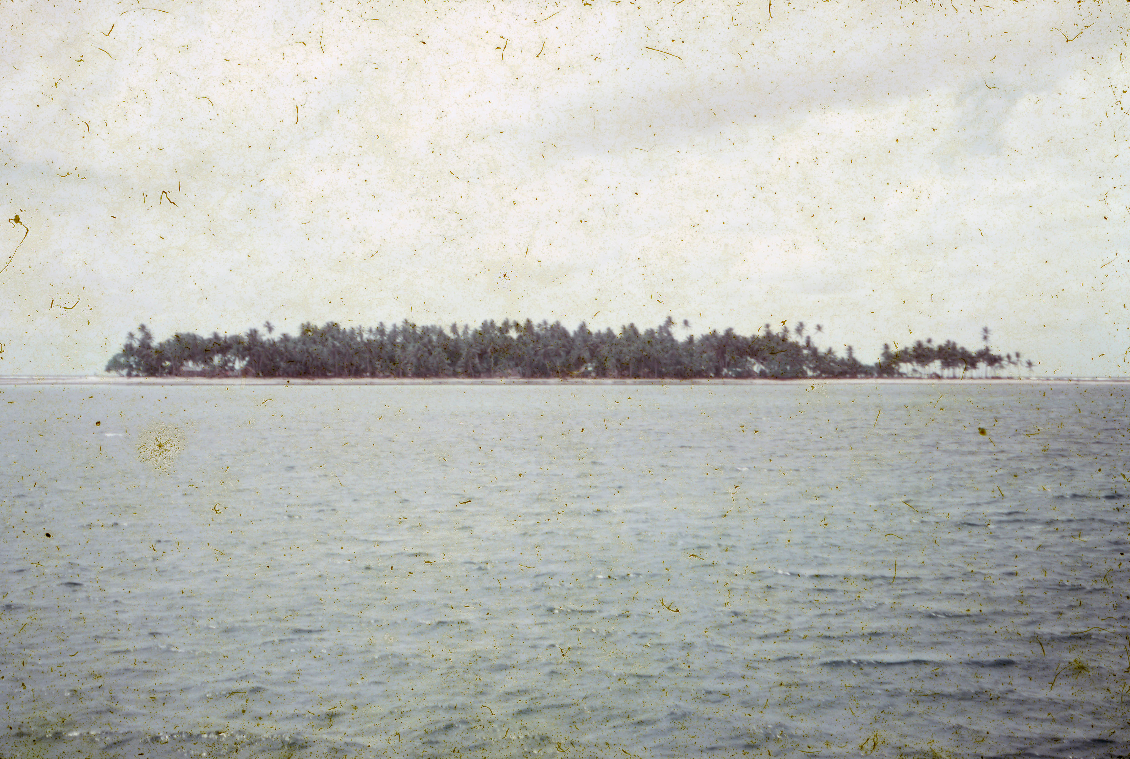 Aged photograph of an island taken at a distance.
