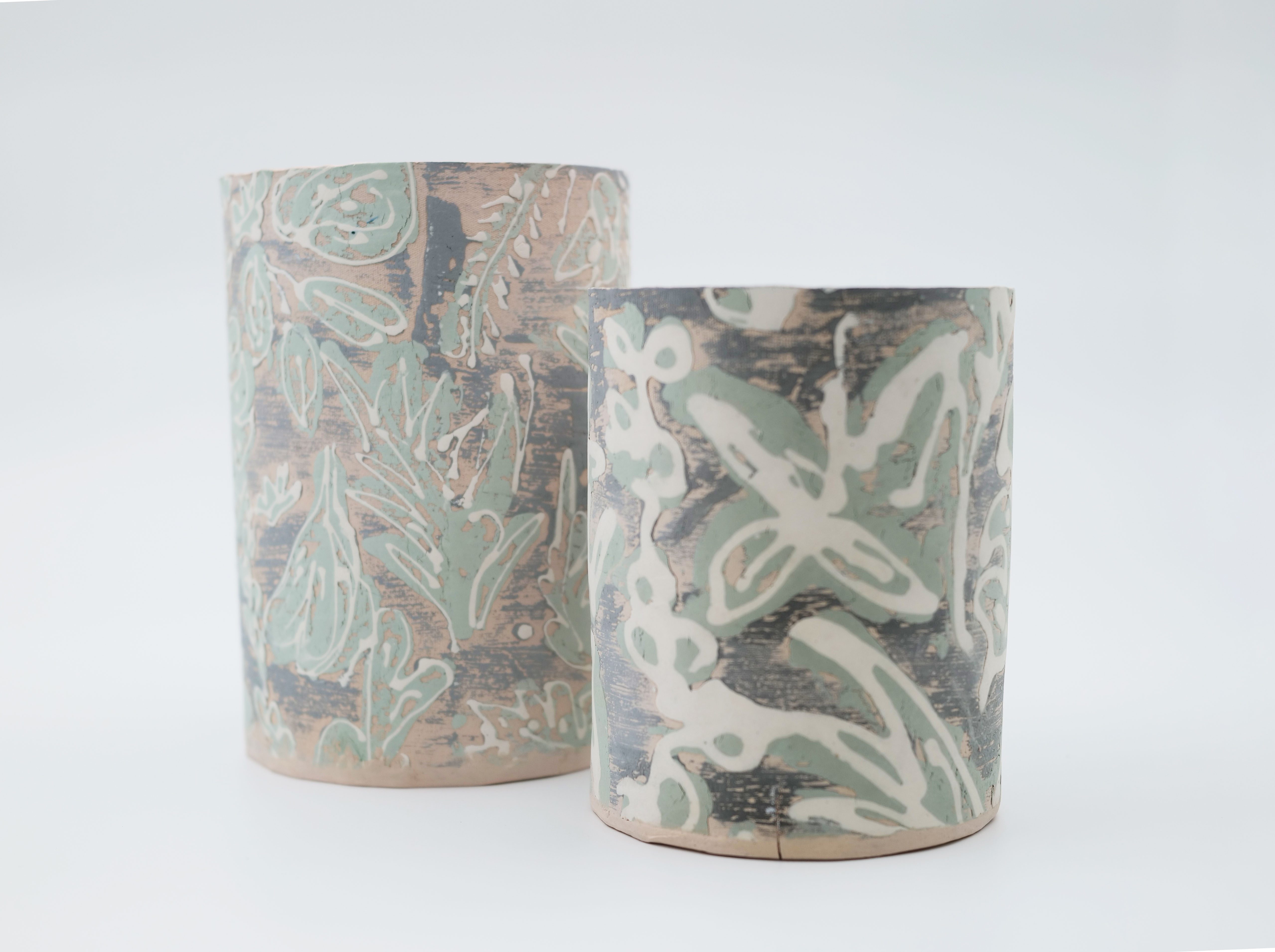 Two mono printed clay vases with a floral pattern.
