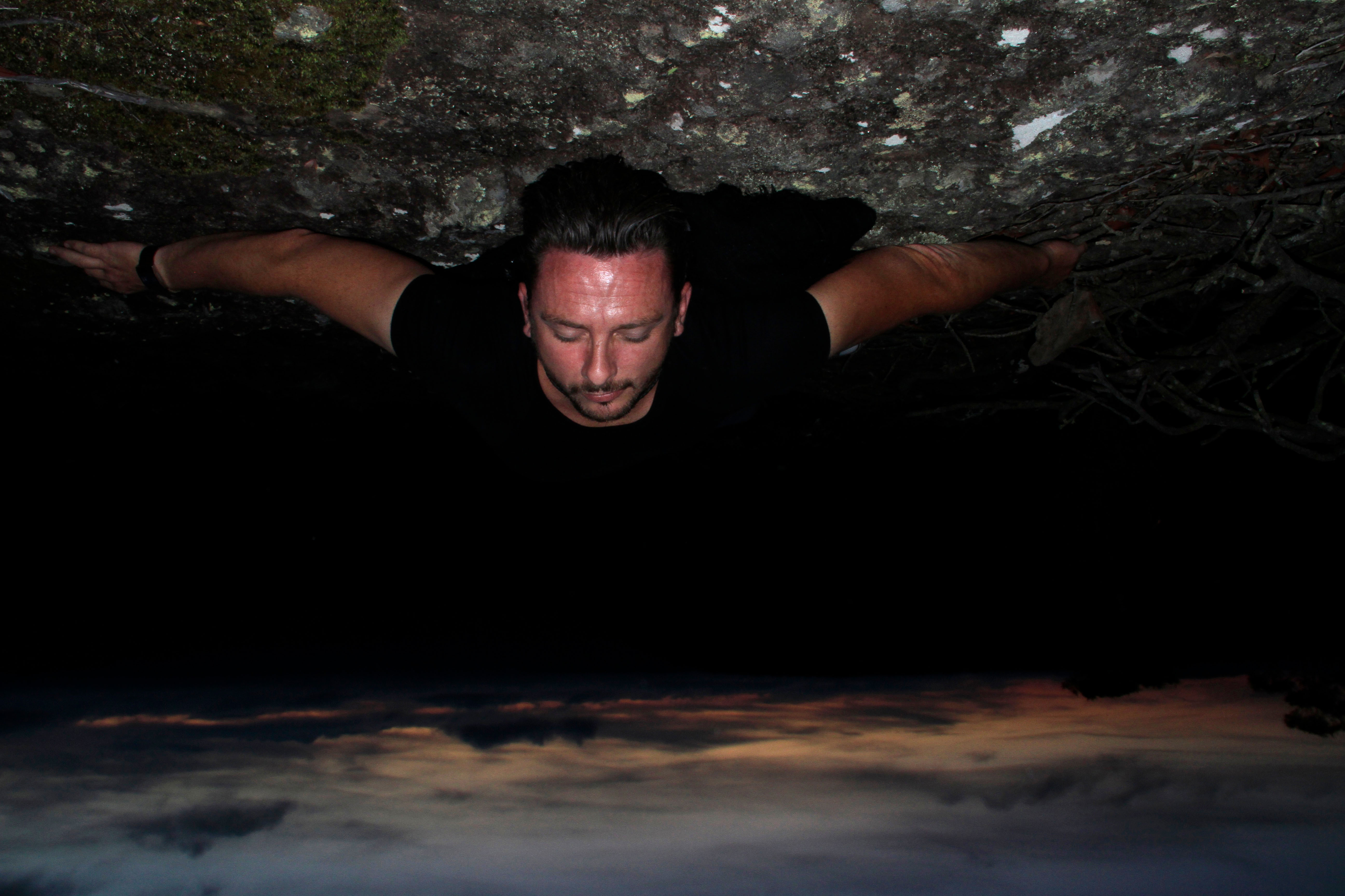 An upside down still of a man laying on the ground outdoors at night.