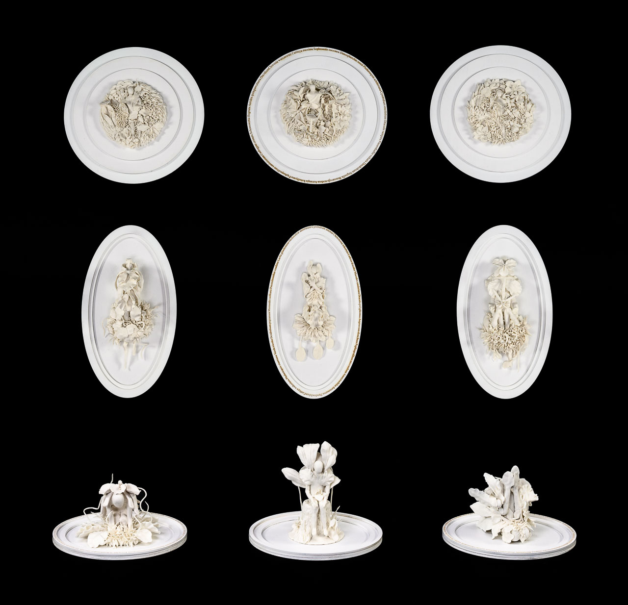 A series of white flowerlike porcelain sculptures on oval plates.