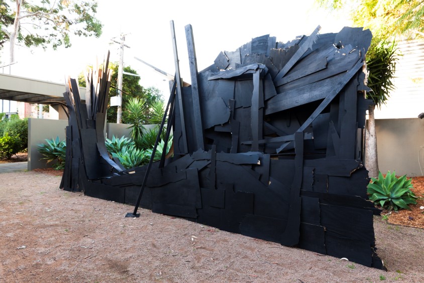 A large black structure of found materials
