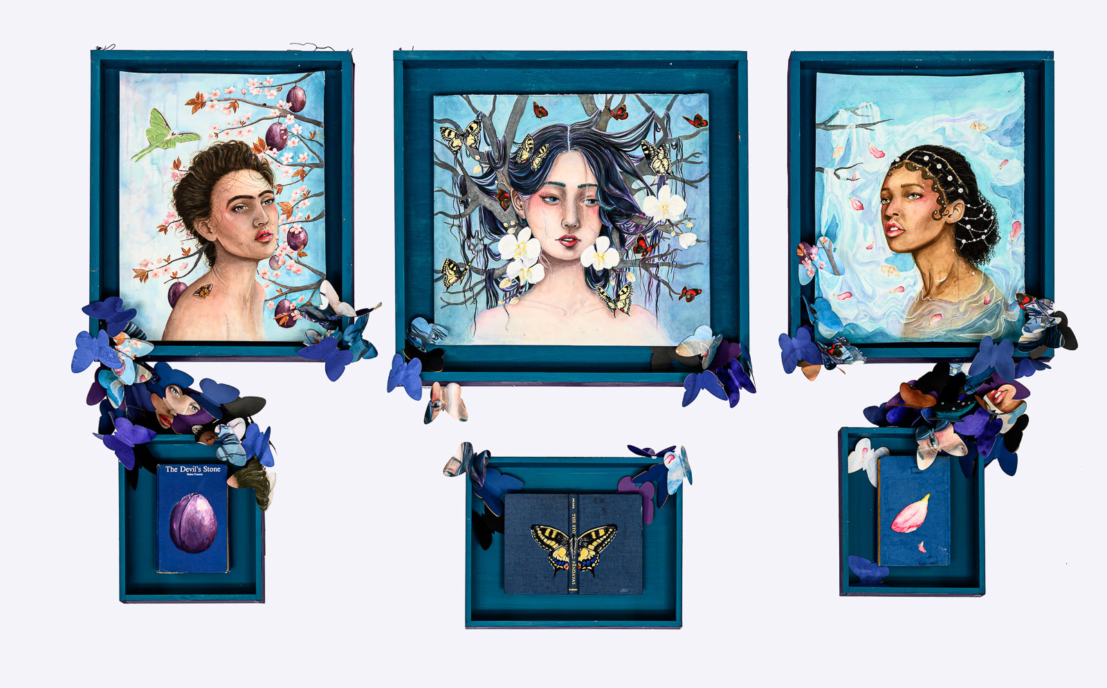 Three blue framed portraits of feminine female faces adorned with butterflies. There are also three smaller framed objects, also in blue. The frames are linked with 3D butterflies stuck to them.