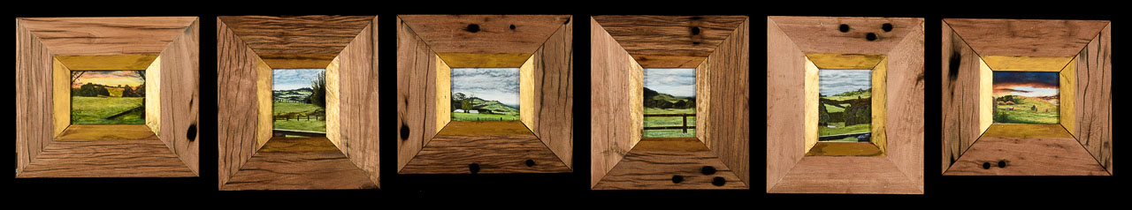 A series of six small rural landscape paintings in heavy wooden frames that are wider then the paintings.