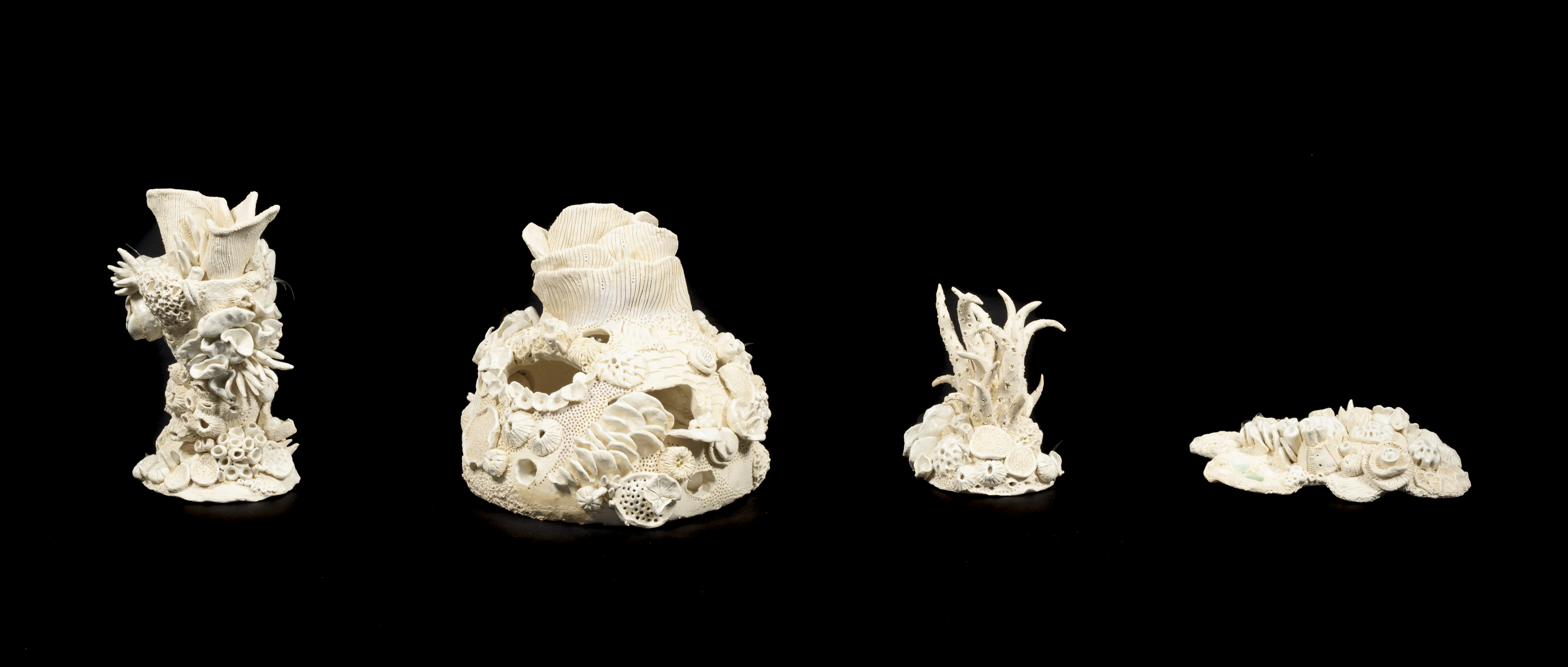 Four ceramic sculptures of various sizes that look like bleached coral structures.