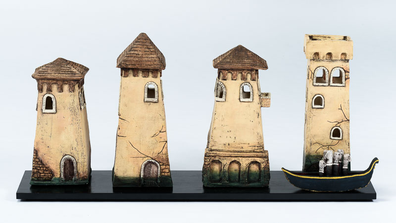 Four ceramic towers on a black base with a gondola.
