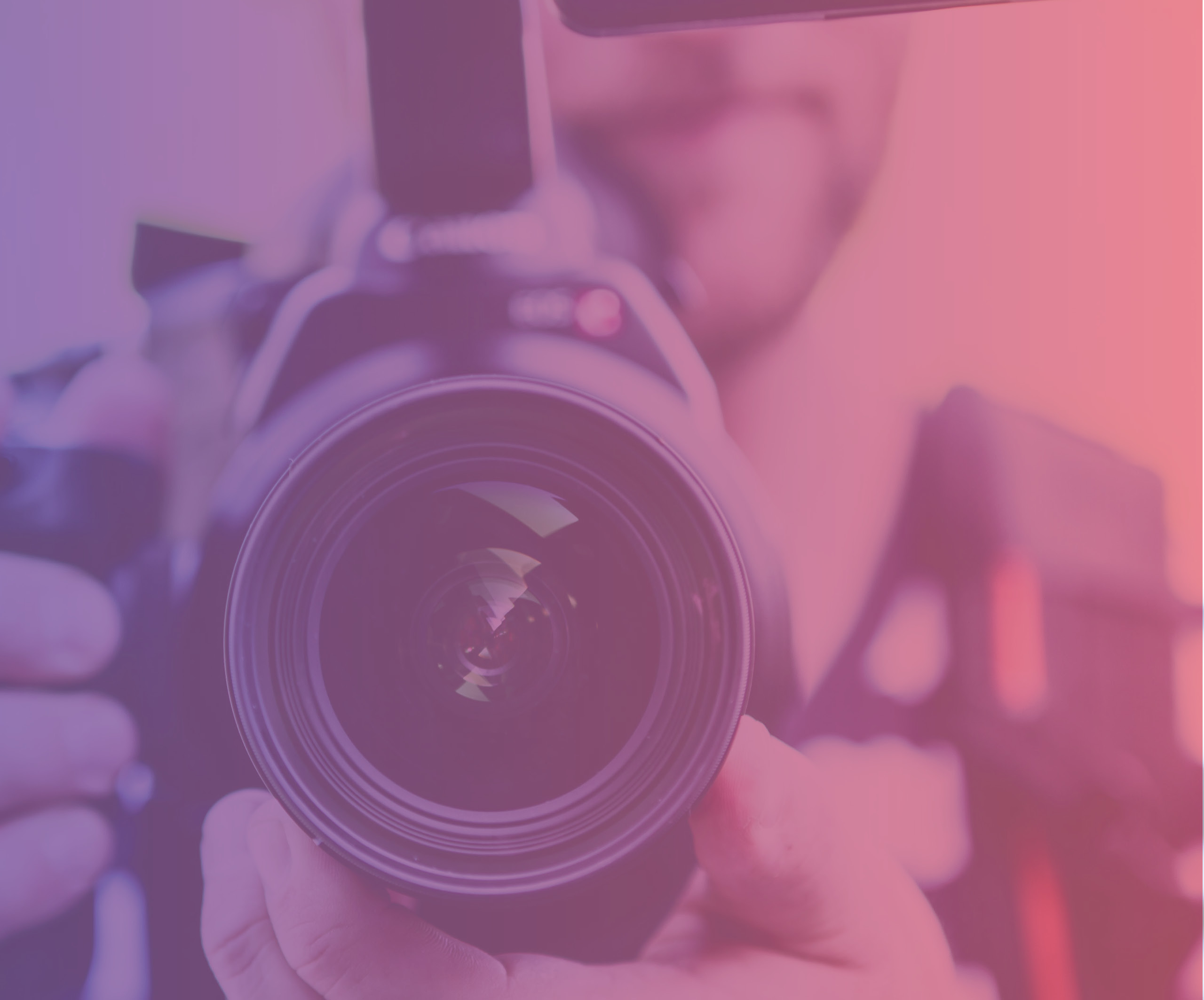 A photograph of a man holding a video camera front on with a purple to pink gradient colour overlay.